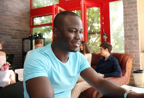 Portrait d'un heureux entrepreneur afro-américain affichant un ordinateur au bureau . — Photo