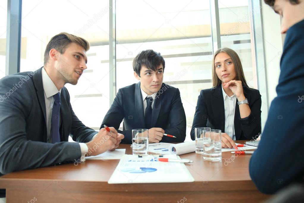 Businesspeople discussing together in conference room during meeting at office.