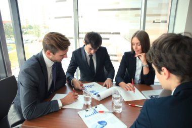 Şirketin çalışmalarında kaydedilen ilerlemeyi gösteren mali rakamları analiz eden bir iş danışmanı.