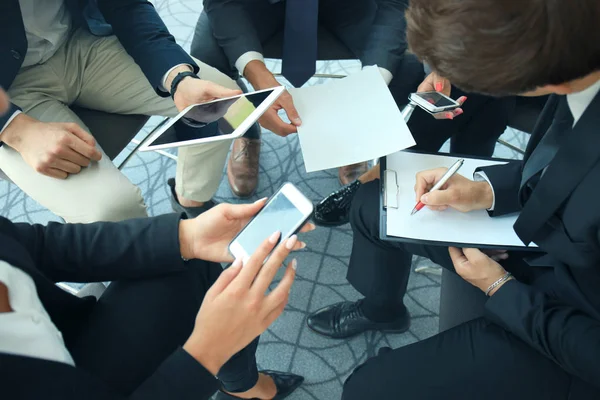 Grupo de pessoas usando telefones inteligentes sentados na reunião, de perto nas mãos . — Fotografia de Stock