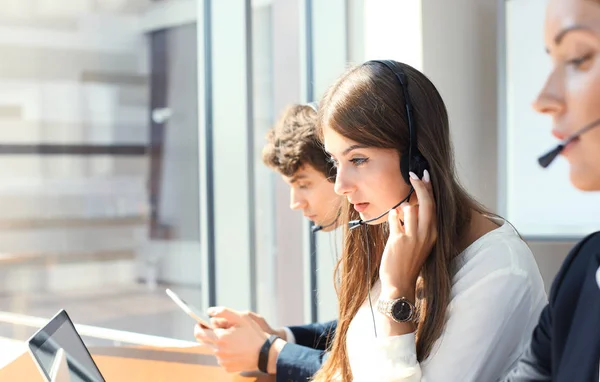 Atractivos jóvenes empresarios y colegas positivos en una oficina de call center. —  Fotos de Stock