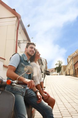 mutlu genç çift sürme scooter şehirde. Yakışıklı ve genç kadın seyahat. Macera ve tatil kavramı.