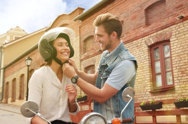 mutlu genç çift sürme scooter şehirde. Yakışıklı ve genç kadın seyahat. Macera ve tatil kavramı.