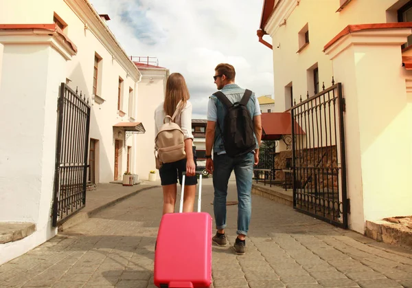 Dois viajantes em férias andando pela cidade com bagagem . — Fotografia de Stock