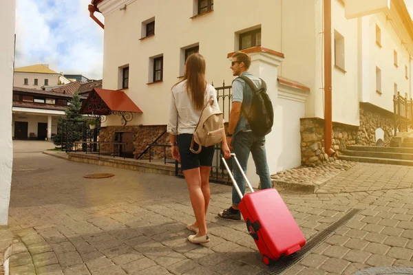 Deux voyageurs en vacances se promènent dans la ville avec leurs bagages . — Photo