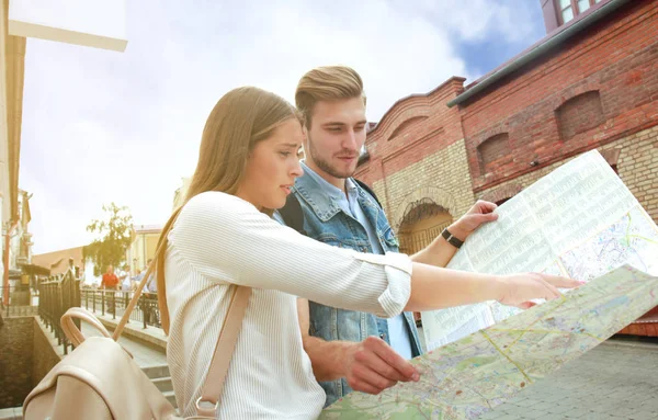 Pareja feliz caminando al aire libre haciendo turismo y sosteniendo un mapa . —  Fotos de Stock