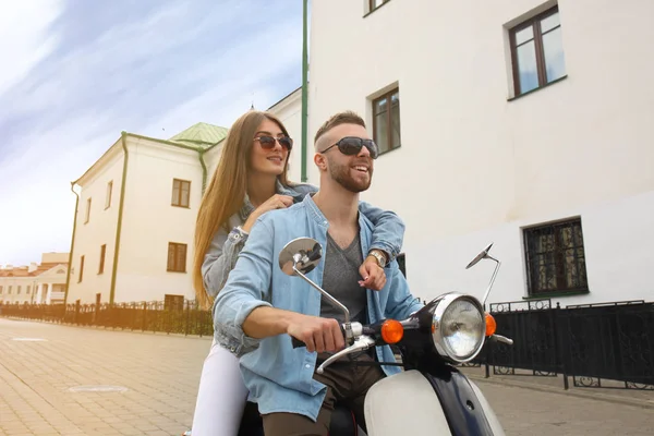 町で幸せな若いカップル乗りスクーター。ハンサムな男と若い女性を旅行します。冒険と休暇の概念. — ストック写真