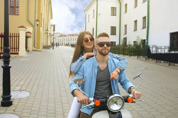町で幸せな若いカップル乗りスクーター。ハンサムな男と若い女性を旅行します。冒険と休暇の概念. — ストック写真