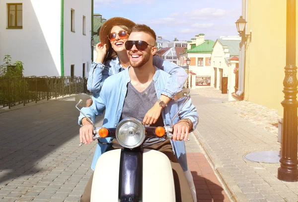 mutlu genç çift sürme scooter şehirde. Yakışıklı ve genç kadın seyahat. Macera ve tatil kavramı.