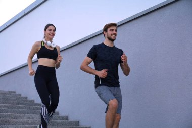 Merdivenlerde koşan atletler. Çift spor salonu dışarıda koşuyor..