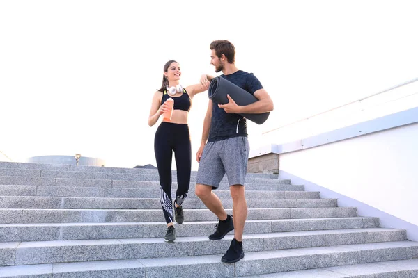 Jovem casal em sportswear descendo as escadas depois de se exercitar ao ar livre. — Fotografia de Stock