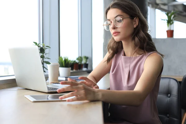 Mulher de negócios bonita em desgaste casual inteligente trabalhando no laptop no escritório — Fotografia de Stock