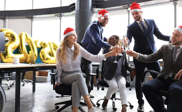 Pessoas de negócios estão comemorando férias no escritório moderno bebendo champanhe e se divertindo em co-working. Feliz Natal e Feliz Ano Novo 2020 — Fotografia de Stock