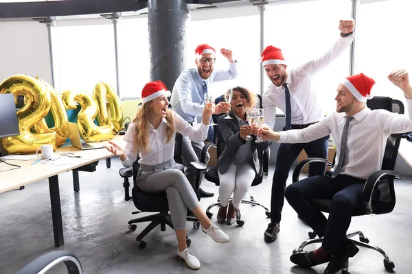 Gli uomini d'affari festeggiano le vacanze nel moderno ufficio bevendo champagne e divertendosi nel coworking. Buon Natale e Felice Anno Nuovo 2020 — Foto Stock