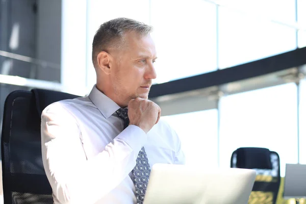 Volwassen zakenman werkt op de computer in het moderne kantoor. — Stockfoto