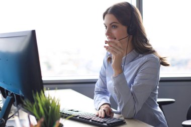 Kulaklıklı ve gülümseyen kadın müşteri destek operatörü.