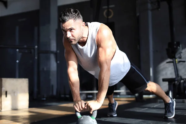 Fitter und muskulöser Mann beim Heben einer Hantel während einer Gymnastikstunde im Fitnessstudio. — Stockfoto