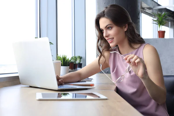 Bella donna d'affari in abbigliamento casual intelligente che lavora sul computer portatile in ufficio — Foto Stock