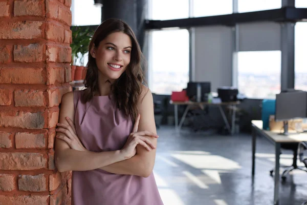 Attrayant femme d'affaires souriant tout en se tenant dans le bureau. — Photo