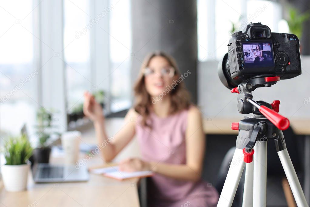 Beautiful young woman talking and smiling while making new video for her blog.