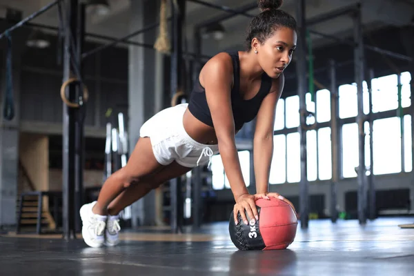 Passform och muskulös kvinna tränar med medicinboll på gymmet. — Stockfoto