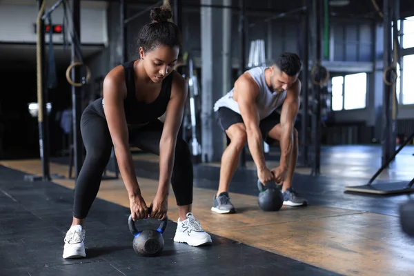 Ajuste y pareja muscular se centró en levantar una mancuerna durante una clase de ejercicio en un gimnasio. — Foto de Stock