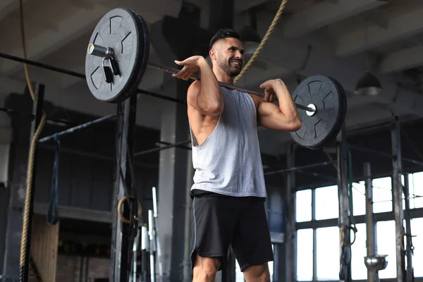 Muskularny mężczyzna, poćwiczyć w siłowni, ćwiczenia ze sztangą na biceps. — Zdjęcie stockowe