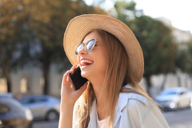 Güzel sarışın kız dışarıda beklerken cep telefonu kullanıyor..