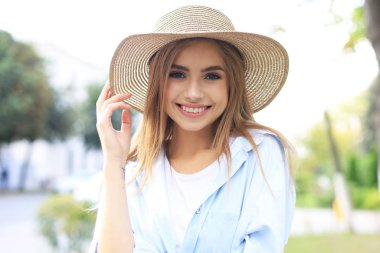 Şehirde poz veren güzel bir kızın portresi, yaz sokak modası..