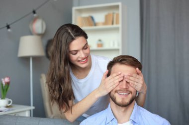 Kocasının gözlerini kapatan hoş bir kadın..