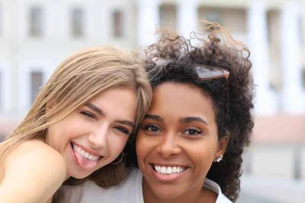Jeunes femmes hipster souriantes en vêtements d'été posant dans la rue.Femme montrant des émotions positives au visage . — Photo
