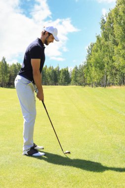 Güneşli bir günde golf oynayan golf oyuncusu tam uzunlukta. Profesyonel erkek golfçü golf sahasında çekim alarak.