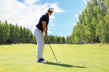 Güneşli bir günde golf oynayan golf oyuncusu tam uzunlukta. Profesyonel erkek golfçü golf sahasında çekim alarak.