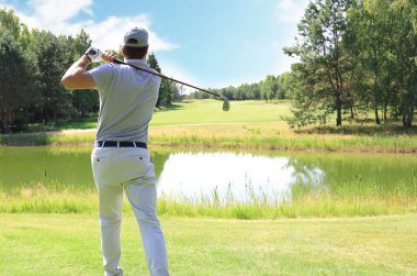 Golf kulübünde golf oynayan atletik genç adam.