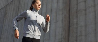 Açık havada gündoğumu veya günbatımı şehirde egzersiz yaparken çalışan genç çekici sportif fitness kadın