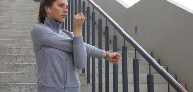 Çekici sportif kadın kollarını germe ve açık havada konsantre görünümlü