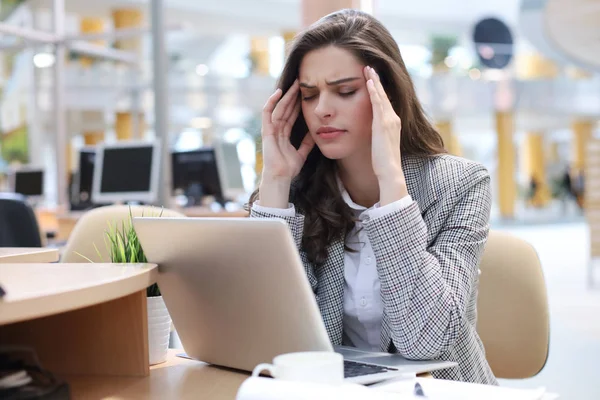 Frustrierte Geschäftsfrau sieht am Arbeitsplatz erschöpft aus — Stockfoto