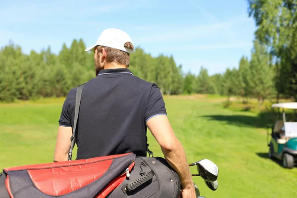 Игрок в гольф ходит и несет сумку на поле во время летних игр в гольф. — стоковое фото