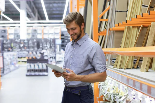 Manager używa tabletu do sprawdzania dostępnych produktów online. — Zdjęcie stockowe