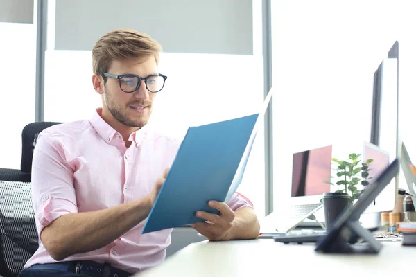 Succesvolle ondernemer bestudeert documenten met een attente en geconcentreerde blik — Stockfoto