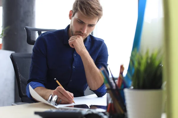 Skjuten av en stilig manlig arkitekt som arbetar med en design på sitt kontor. — Stockfoto