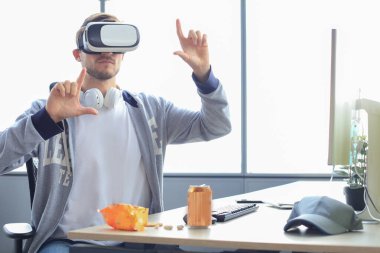 Modern iç tasarım ortak çalışma stüdyosunda sanal gerçeklik gözlüğü takan genç sakallı adam..