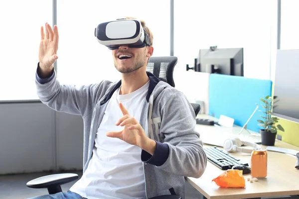 Junger Mann spielt mit Virtual-Reality-Headset im Spielclub. — Stockfoto