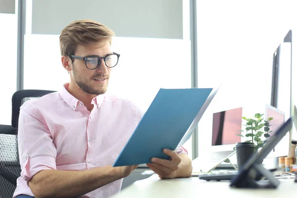 Succesvolle ondernemer bestudeert documenten met een attente en geconcentreerde blik — Stockfoto