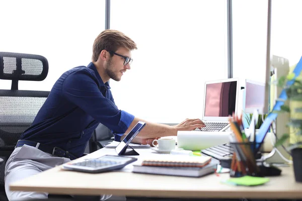 Elegante hombre de negocios moderno analizando datos mientras trabaja en la oficina — Foto de Stock