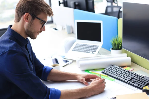 Fotografía de un apuesto arquitecto masculino trabajando en un diseño en su oficina . — Foto de Stock