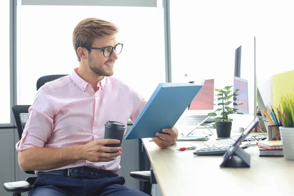 Succesvolle ondernemer bestudeert documenten met een attente en geconcentreerde blik — Stockfoto