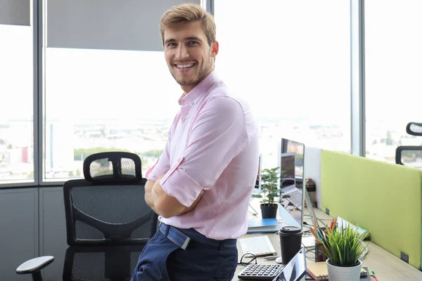 Retrato del joven sentado en su escritorio en la oficina. — Foto de Stock