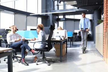 Bir grup mutlu ilerici iş adamı yaratıcı ofiste birlikte çalışıyor.