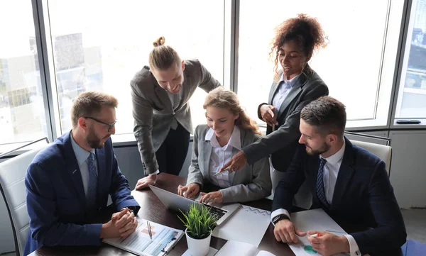 Groep jonge moderne mensen in formalwear glimlachend en bespreekt iets tijdens het werken in het moderne kantoor — Stockfoto